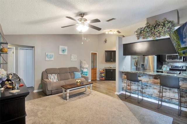 2816 Manor Hill Dr, Brandon, FL 33511 - living area with vaulted ceiling, a ceiling fan, wood finished floors, a textured ceiling, and baseboards