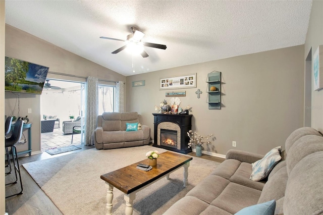 2816 Manor Hill Dr, Brandon, FL 33511 - living room with ceiling fan, lofted ceiling, a glass covered fireplace, a textured ceiling, and wood finished floors