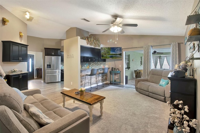 2816 Manor Hill Dr, Brandon, FL 33511 - living area with lofted ceiling, ceiling fan, a textured ceiling, and light wood-type flooring