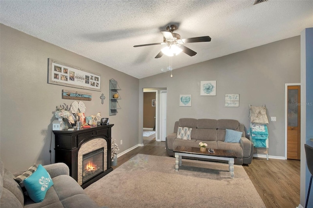 2816 Manor Hill Dr, Brandon, FL 33511 - living area featuring vaulted ceiling, ceiling fan, wood finished floors, a textured ceiling, and a glass covered fireplace