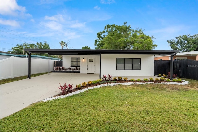 mid-century modern home featuring a carport, stucco siding, and driveway