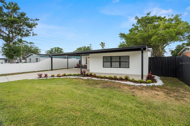 view of front of home with stucco siding, a carport, and driveway
