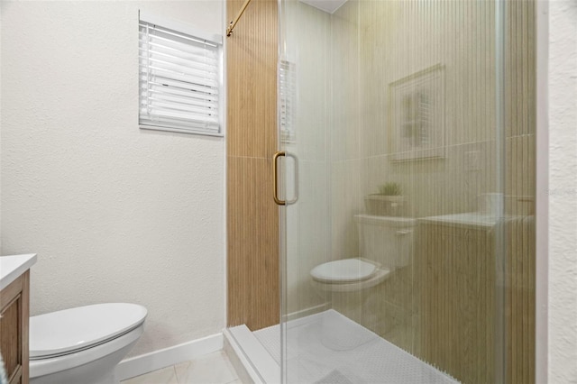 bathroom with vanity, toilet, a stall shower, tile patterned flooring, and baseboards