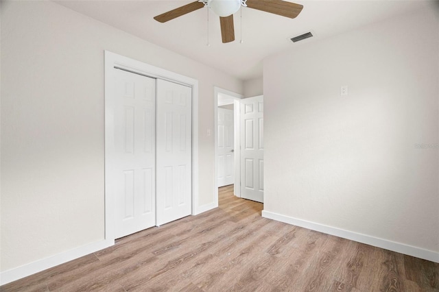 unfurnished bedroom with a closet, wood finished floors, and baseboards
