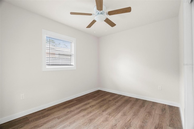 spare room with wood finished floors, baseboards, and a ceiling fan