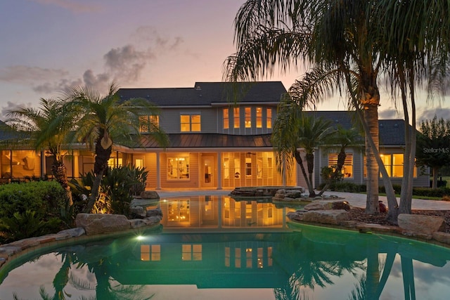 17129 Breeders Cup Dr, Odessa, FL 33556 - rear view of house with an outdoor pool, a standing seam roof, and metal roof
