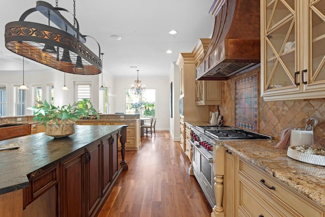 17129 Breeders Cup Dr, Odessa, FL 33556 - kitchen with custom range hood, double oven range, cream cabinets, wood finished floors, and decorative backsplash