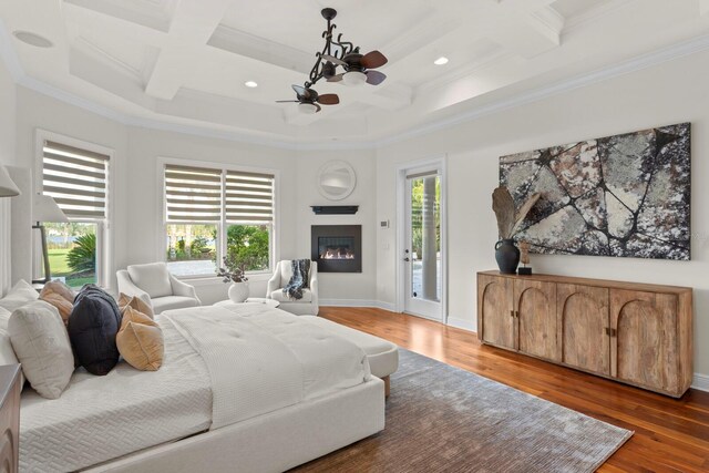 17129 Breeders Cup Dr, Odessa, FL 33556 - bedroom with coffered ceiling, ornamental molding, multiple windows, wood finished floors, and a glass covered fireplace