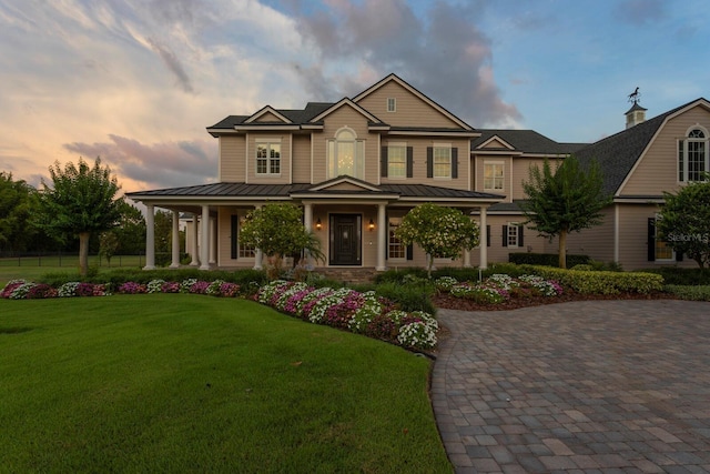 17129 Breeders Cup Dr, Odessa, FL 33556 - view of front of property featuring a porch, a standing seam roof, a lawn, and metal roof