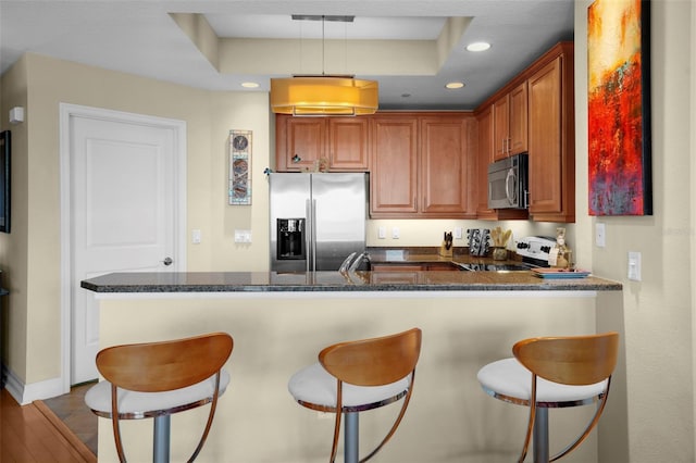 449 S 12th St Unit 2205, Tampa, FL 33602 - kitchen with appliances with stainless steel finishes, a peninsula, recessed lighting, a kitchen bar, and dark stone counters