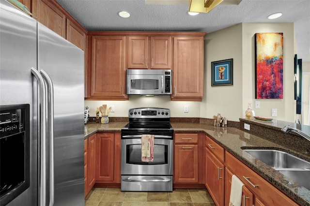 449 S 12th St Unit 2205, Tampa, FL 33602 - kitchen with appliances with stainless steel finishes, a sink, brown cabinets, dark stone counters, and recessed lighting