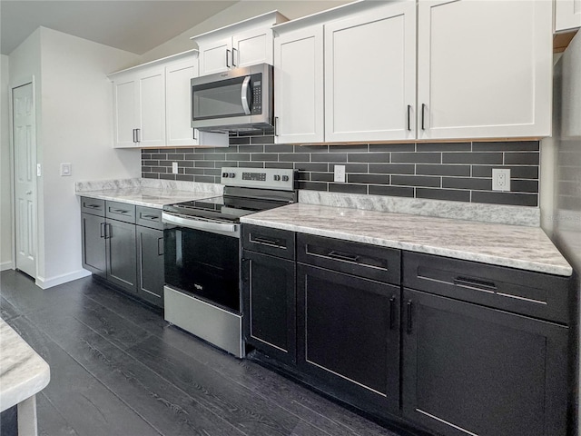kitchen with appliances with stainless steel finishes, dark wood-style floors, white cabinetry, baseboards, and decorative backsplash