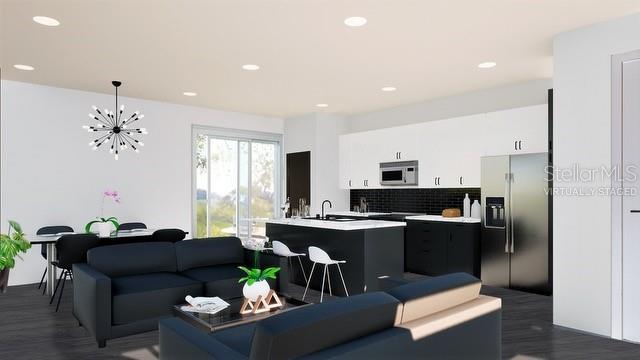living area with recessed lighting, dark wood-style floors, and a chandelier