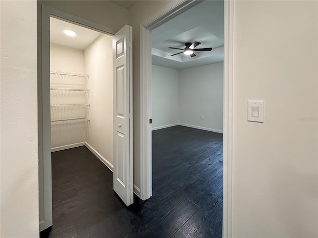 hall with dark wood-style floors and baseboards