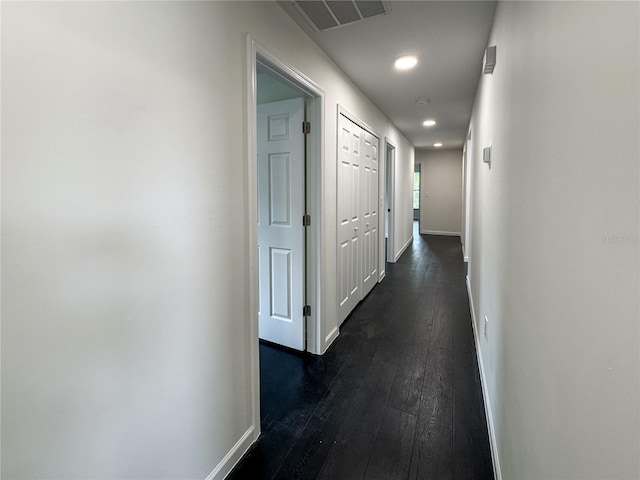 corridor featuring dark wood finished floors, baseboards, and recessed lighting