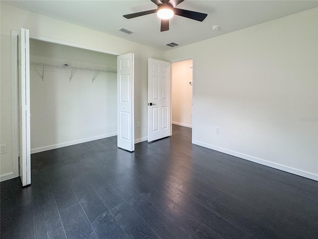 unfurnished bedroom with dark wood-style flooring, baseboards, a ceiling fan, and a closet