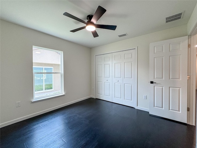 unfurnished bedroom featuring dark wood-type flooring, baseboards, a closet, and ceiling fan