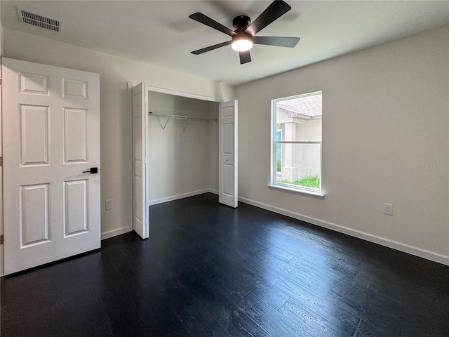 unfurnished bedroom with a closet, baseboards, dark wood-style floors, and a ceiling fan