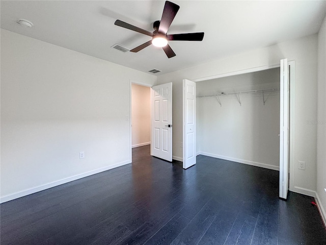 unfurnished bedroom with dark wood-style flooring, baseboards, a ceiling fan, and a closet