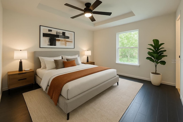 bedroom with a tray ceiling, baseboards, dark wood finished floors, and a ceiling fan
