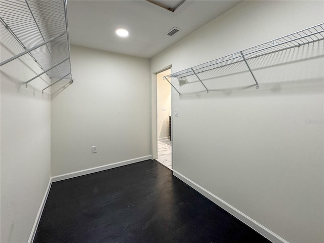 walk in closet with dark wood-style flooring
