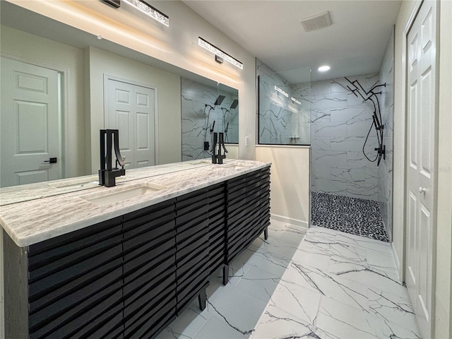 bathroom featuring marble look tile flooring, a marble finish shower, double vanity, and recessed lighting