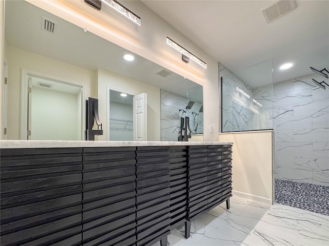 full bathroom featuring marble finish floors, a marble finish shower, recessed lighting, and a walk in closet