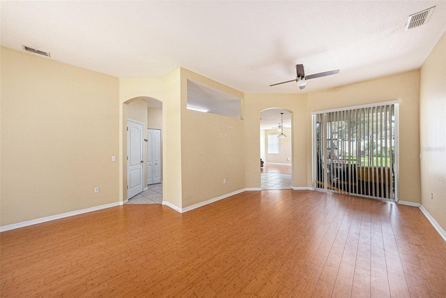 1744 Brookstone Way, Plant City, FL 33566 - empty room featuring arched walkways, ceiling fan, and light wood-style floors