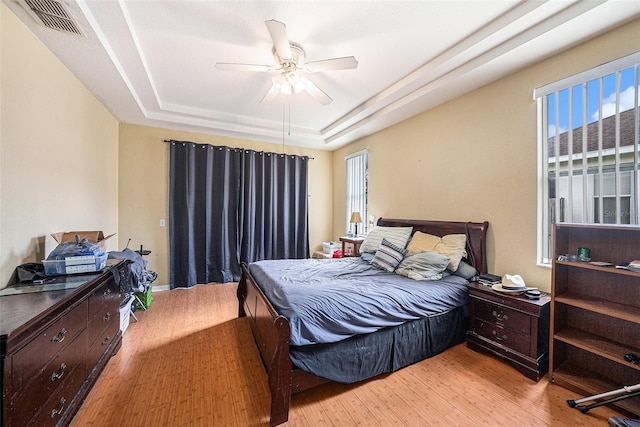 1744 Brookstone Way, Plant City, FL 33566 - bedroom with a tray ceiling, light wood finished floors, multiple windows, and ceiling fan