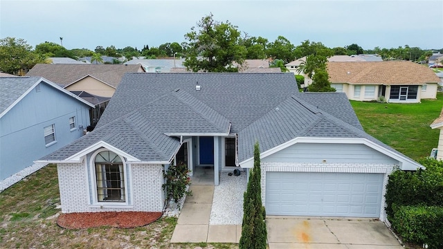 8913 Welsh Way, Hudson, FL 34667 - view of front of house featuring brick siding, an attached garage, driveway, a front lawn, and a residential view