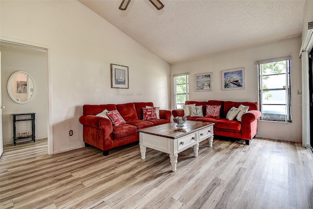8913 Welsh Way, Hudson, FL 34667 - living room featuring light wood finished floors, a textured ceiling, ceiling fan, baseboards, and high vaulted ceiling