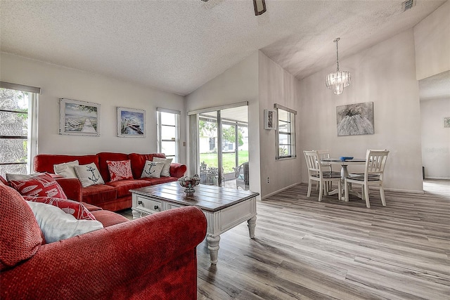 8913 Welsh Way, Hudson, FL 34667 - living room featuring a textured ceiling, wood finished floors, a chandelier, and high vaulted ceiling