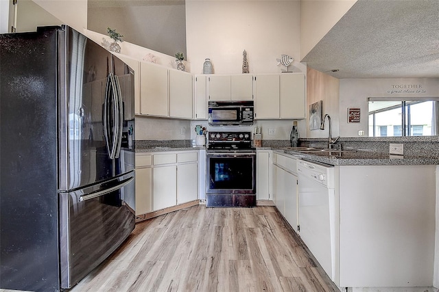 8913 Welsh Way, Hudson, FL 34667 - kitchen with stainless steel appliances, a sink, light wood-type flooring, a peninsula, and a textured ceiling