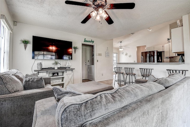 8913 Welsh Way, Hudson, FL 34667 - living area featuring ceiling fan, a textured ceiling, vaulted ceiling, and wood finished floors
