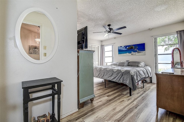 8913 Welsh Way, Hudson, FL 34667 - bedroom with light wood-style flooring, a textured ceiling, and a ceiling fan