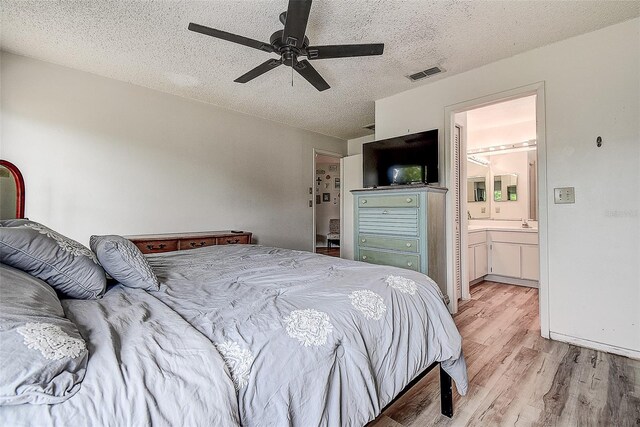 8913 Welsh Way, Hudson, FL 34667 - bedroom featuring light wood-style floors, a textured ceiling, ensuite bathroom, and ceiling fan