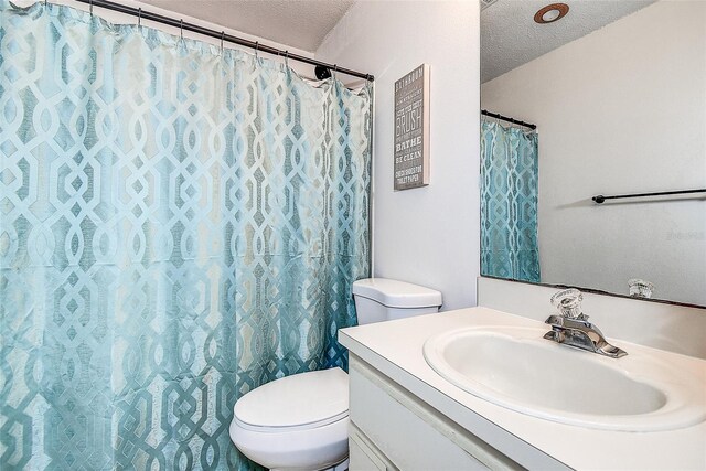 8913 Welsh Way, Hudson, FL 34667 - full bathroom featuring a textured ceiling, toilet, vanity, and curtained shower
