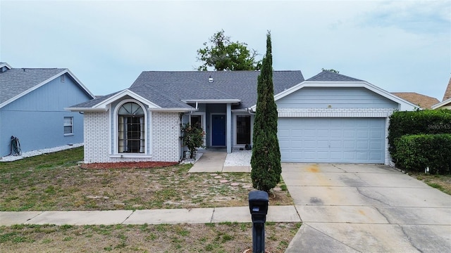 8913 Welsh Way, Hudson, FL 34667 - ranch-style house featuring brick siding, an attached garage, driveway, and roof with shingles