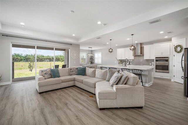923 Whimbrel Run, Bradenton, FL 34212 - living room with light wood-style floors, recessed lighting, baseboards, and a raised ceiling