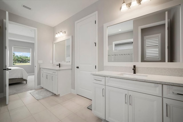 923 Whimbrel Run, Bradenton, FL 34212 - ensuite bathroom featuring two vanities, tile patterned flooring, and baseboards