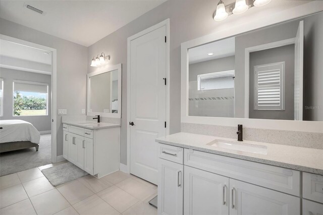 923 Whimbrel Run, Bradenton, FL 34212 - ensuite bathroom featuring healthy amount of natural light, tile patterned floors, two vanities, and baseboards