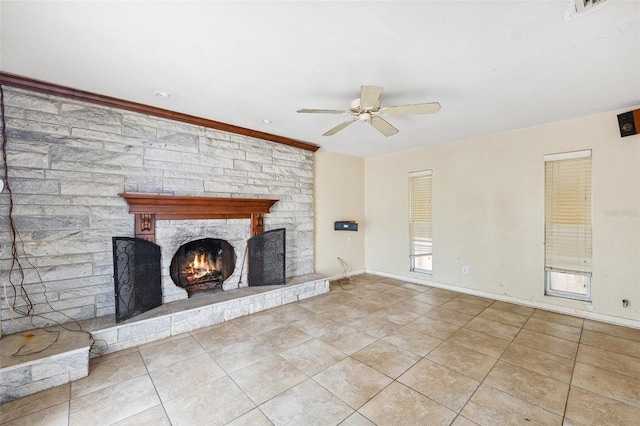 1810 Maryland Ave NE, Saint Petersburg, FL 33703 - unfurnished living room featuring a ceiling fan, tile patterned flooring, a stone fireplace, and baseboards