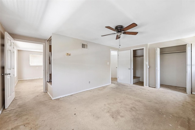 1810 Maryland Ave NE, Saint Petersburg, FL 33703 - unfurnished bedroom with multiple closets, ceiling fan, and light carpet