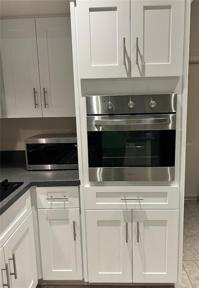 9220 Dayflower Dr, Tampa, FL 33647 - kitchen featuring stainless steel appliances, white cabinetry, and light tile patterned flooring