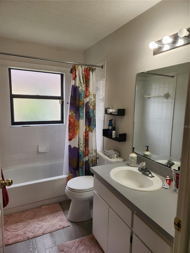 9220 Dayflower Dr, Tampa, FL 33647 - full bathroom with wood finished floors, toilet, vanity, shower / tub combo with curtain, and a textured ceiling