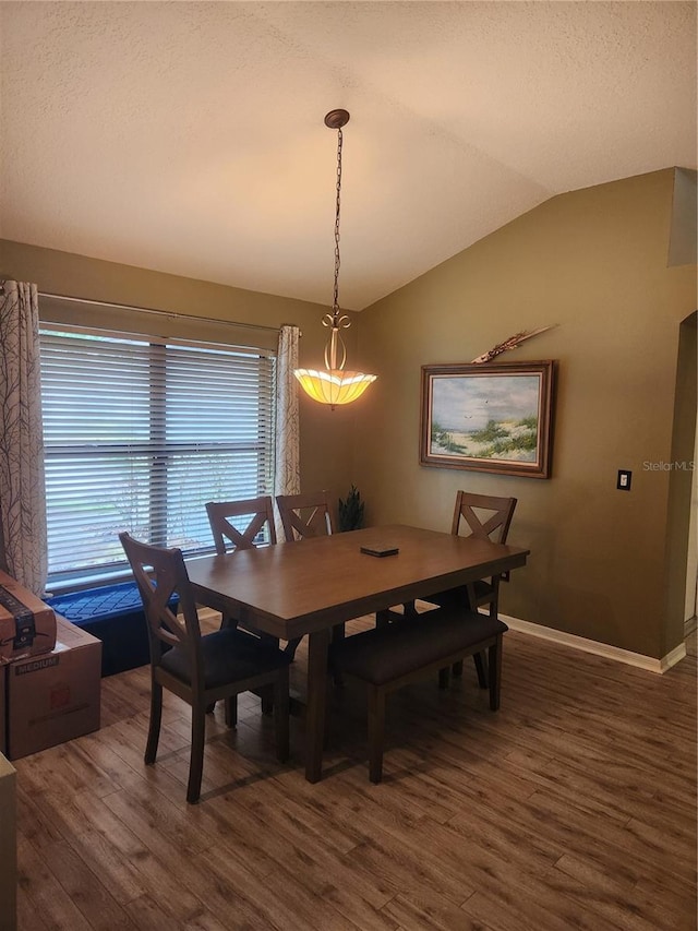 9220 Dayflower Dr, Tampa, FL 33647 - dining area featuring vaulted ceiling, wood finished floors, baseboards, and a textured ceiling