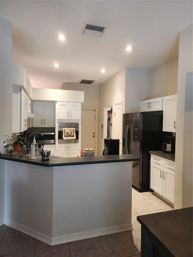 9220 Dayflower Dr, Tampa, FL 33647 - kitchen featuring stainless steel oven, dark countertops, black fridge with ice dispenser, a peninsula, and white cabinetry
