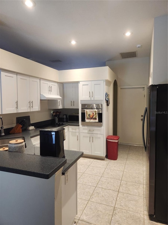 9220 Dayflower Dr, Tampa, FL 33647 - kitchen featuring stainless steel appliances, a peninsula, a sink, dark countertops, and arched walkways