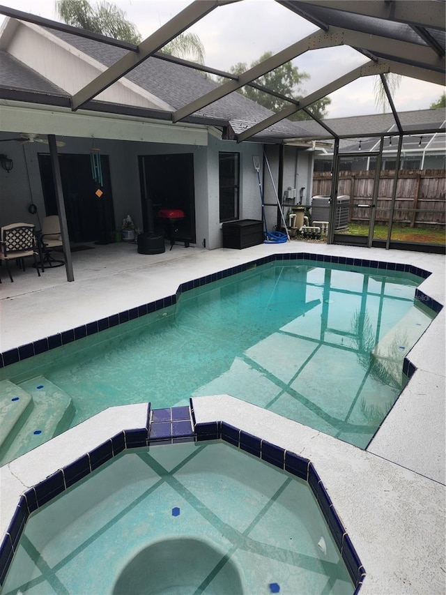 9220 Dayflower Dr, Tampa, FL 33647 - view of pool featuring a patio area, a pool with connected hot tub, fence, and a lanai