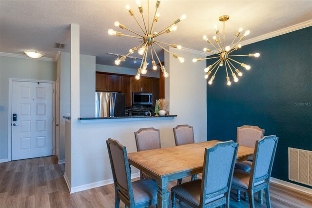 4221 W Spruce St Unit 1303, Tampa, FL 33607 - dining space featuring a chandelier, crown molding, wood finished floors, and baseboards